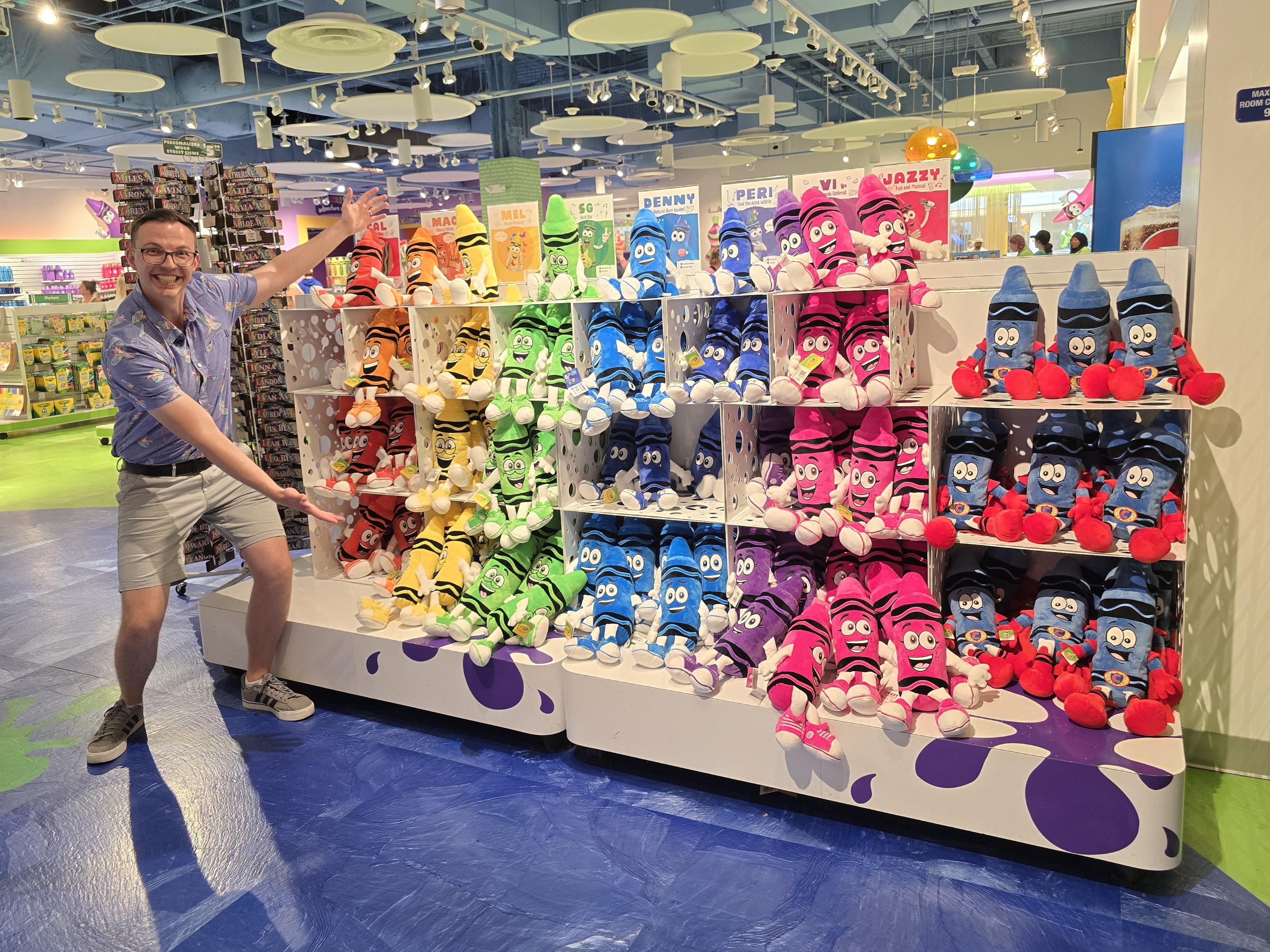 Me standing with a shelf of plush toys at the Crayola Experience